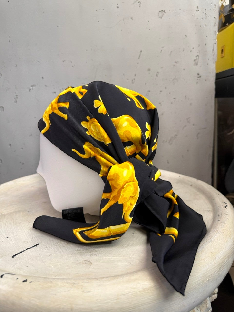 BERLIN VINTAGE CORNER vintage ESCADA silk scarf in black with golden elephant and turtle motif on a mannequin head