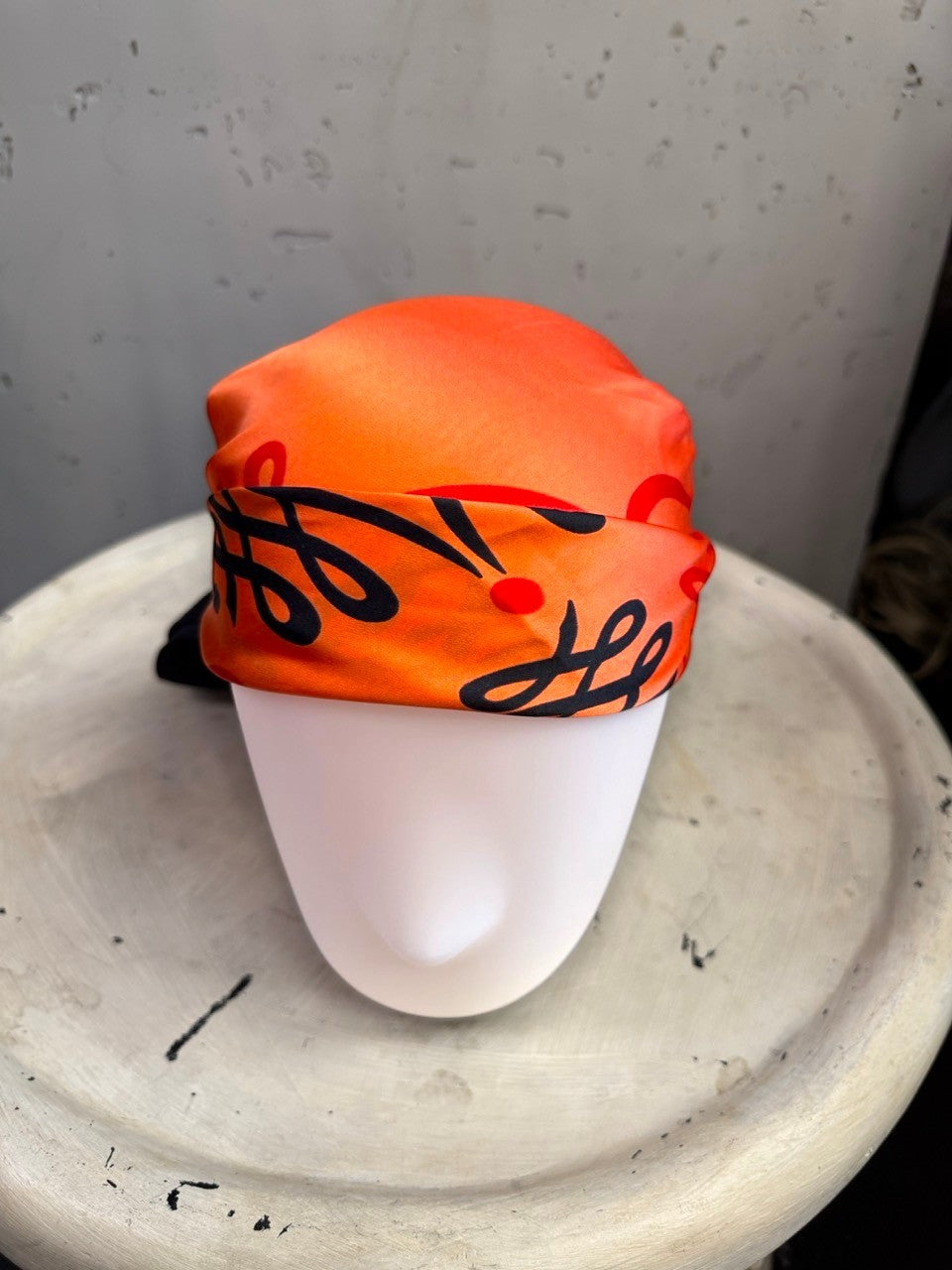 BERLIN VINTAGE CORNER vintage Escada silk scarf in vibrant orange and black with ornate scrollwork on a mannequin head