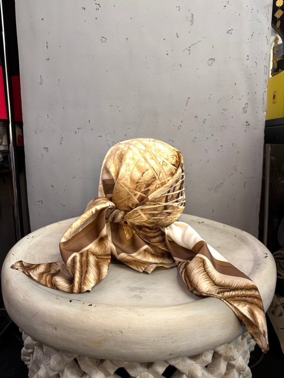 BERLIN VINTAGE CORNER Escada silk scarf in cream and brown with a tiger motif, styled as a headpiece on a pedestal.