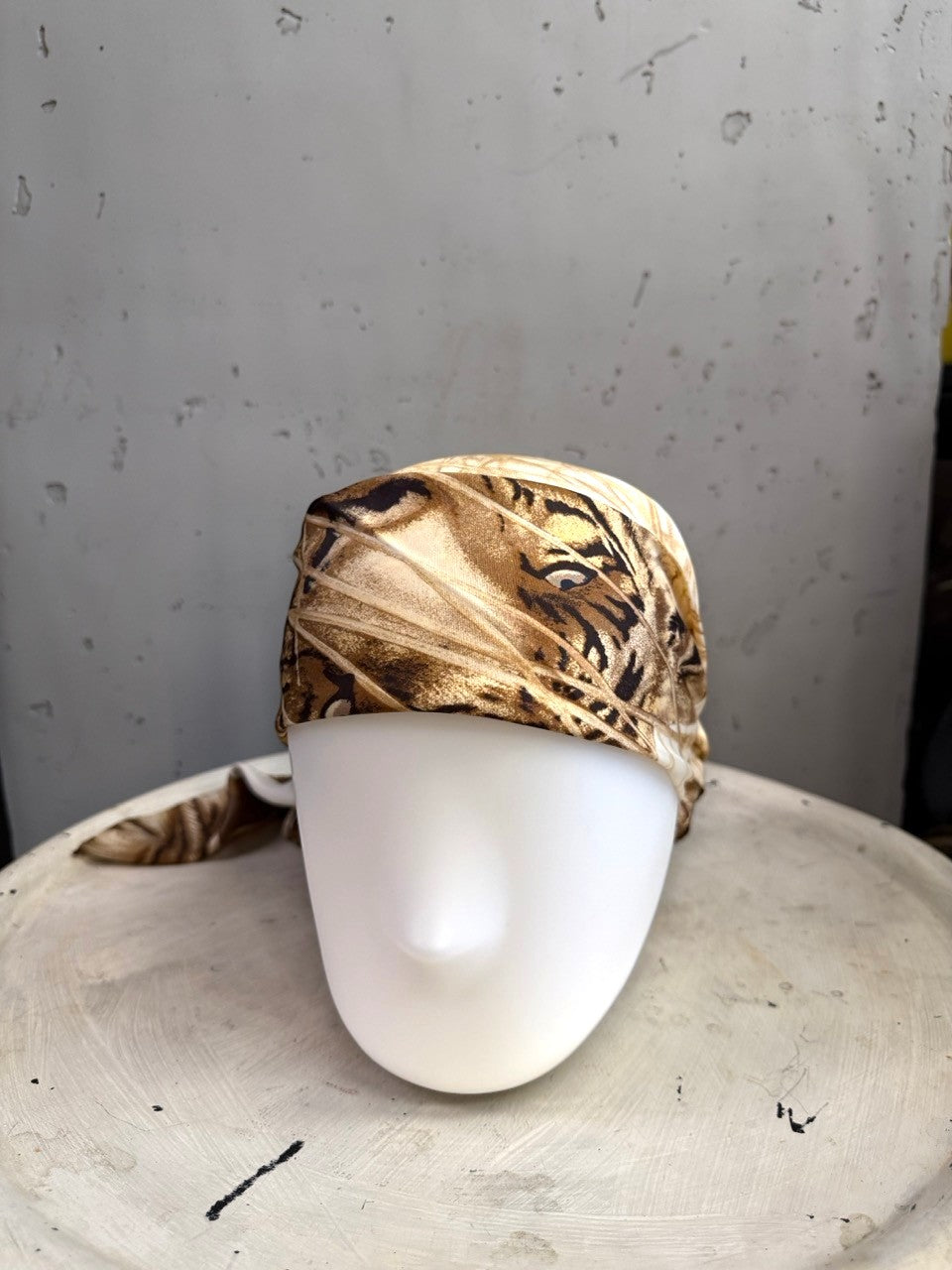BERLIN VINTAGE CORNER Escada silk scarf featuring a tiger motif in cream, tan, and brown, styled as a headpiece.