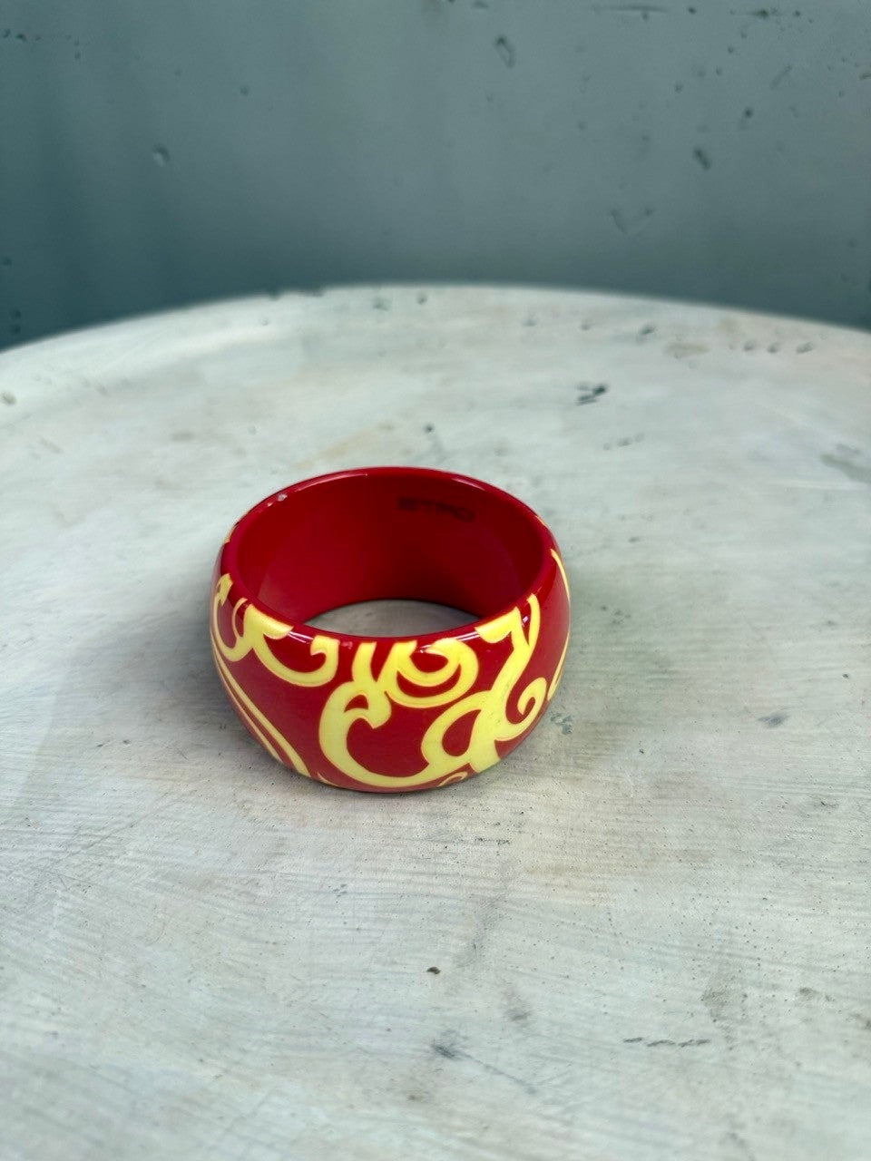 BERLIN VINTAGE CORNER ETRO wide red resin bangle bracelet with a contrasting yellow swirling pattern.