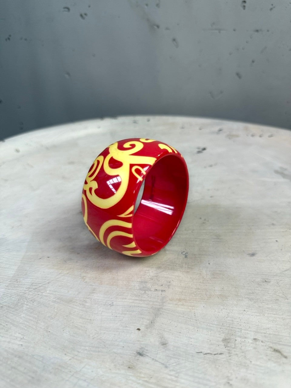 BERLIN VINTAGE CORNER ETRO wide resin bangle bracelet in glossy red with a contrasting yellow swirling pattern.