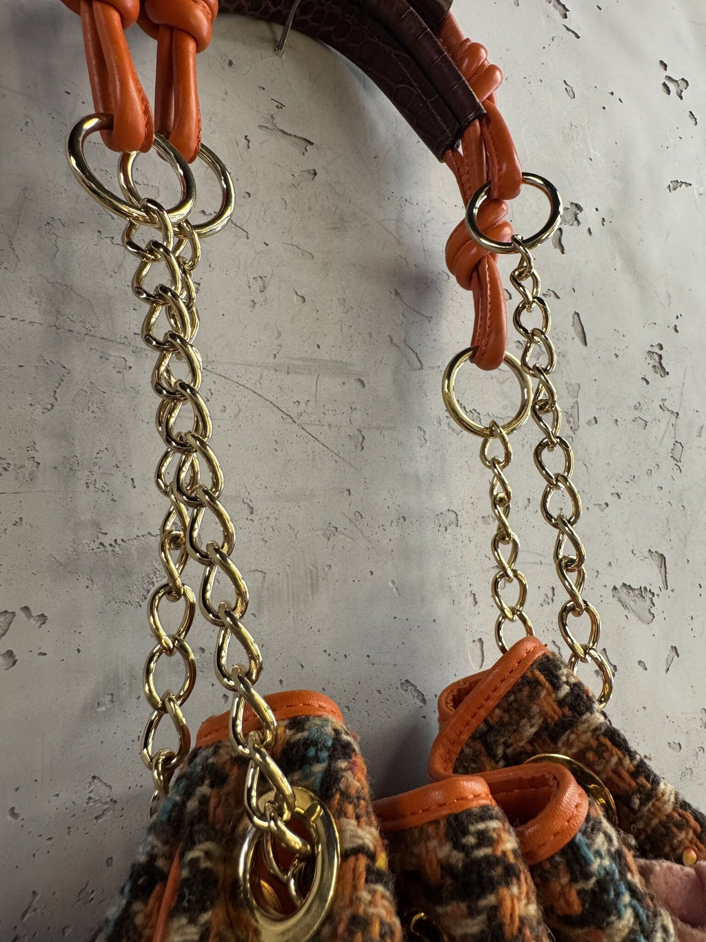 BERLIN VINTAGE CORNER ETRO tweed bucket bag with gold chain straps and orange leather trim against a concrete wall