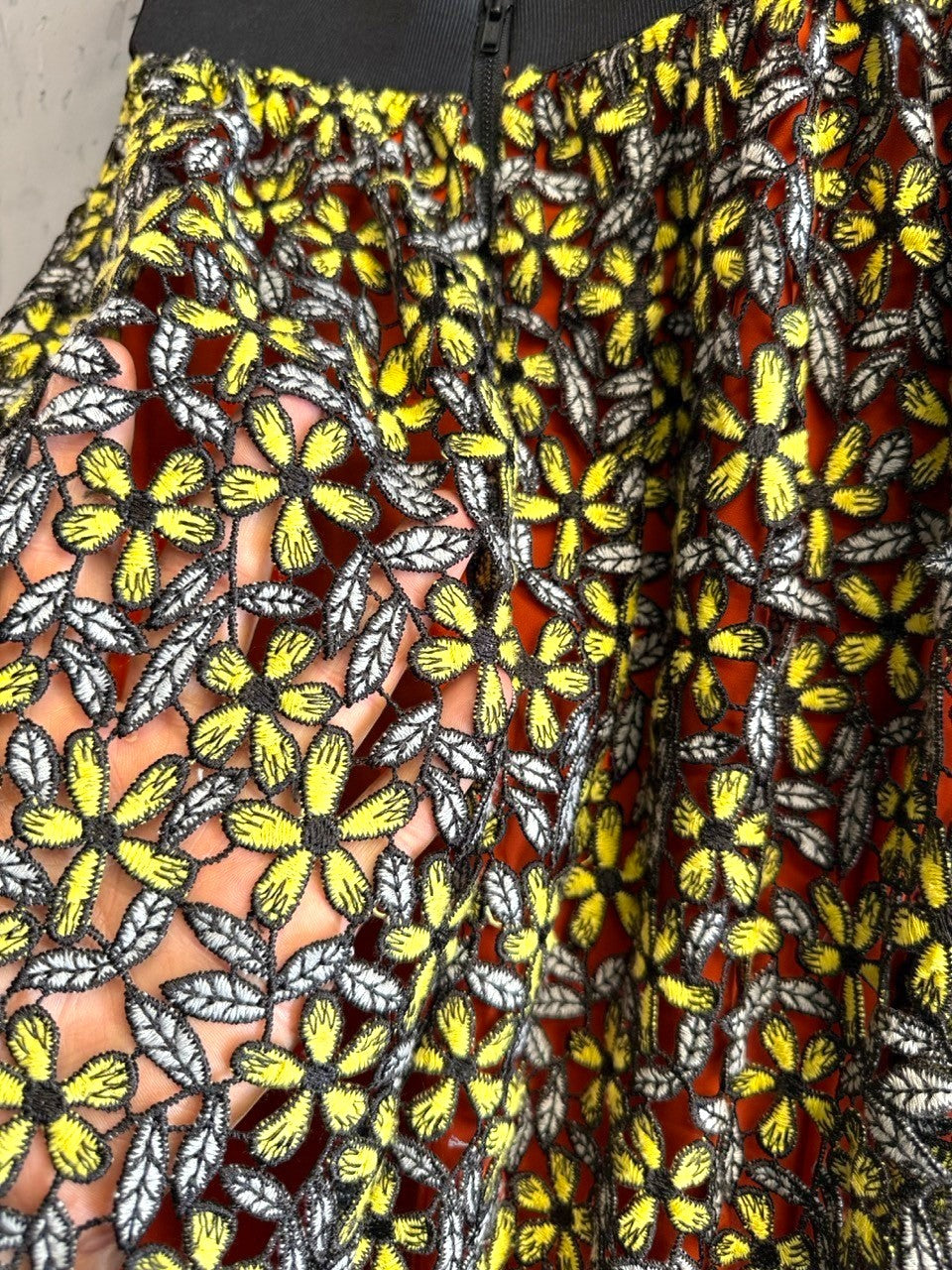 BERLIN VINTAGE CORNER Self-Portrait floral lace midi skirt with orange lining, yellow flowers, grey leaves, and black elastic waistband.