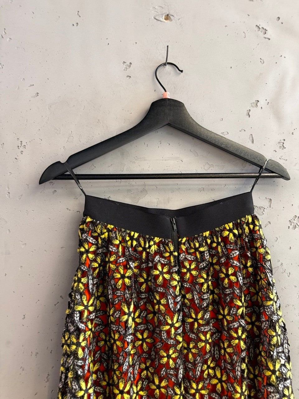 BERLIN VINTAGE CORNER floral lace midi skirt with orange lining, yellow flowers, grey leaves, and black elastic waistband.