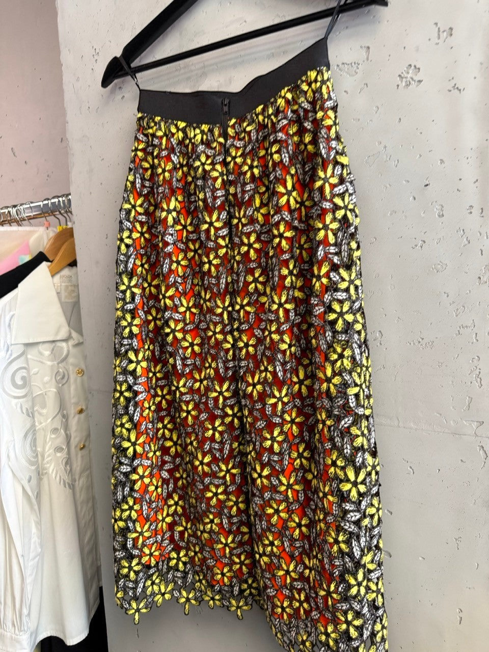 BERLIN VINTAGE CORNER Self-Portrait floral lace midi skirt with orange lining, yellow embroidered flowers, grey leaves, and black elastic waistband.