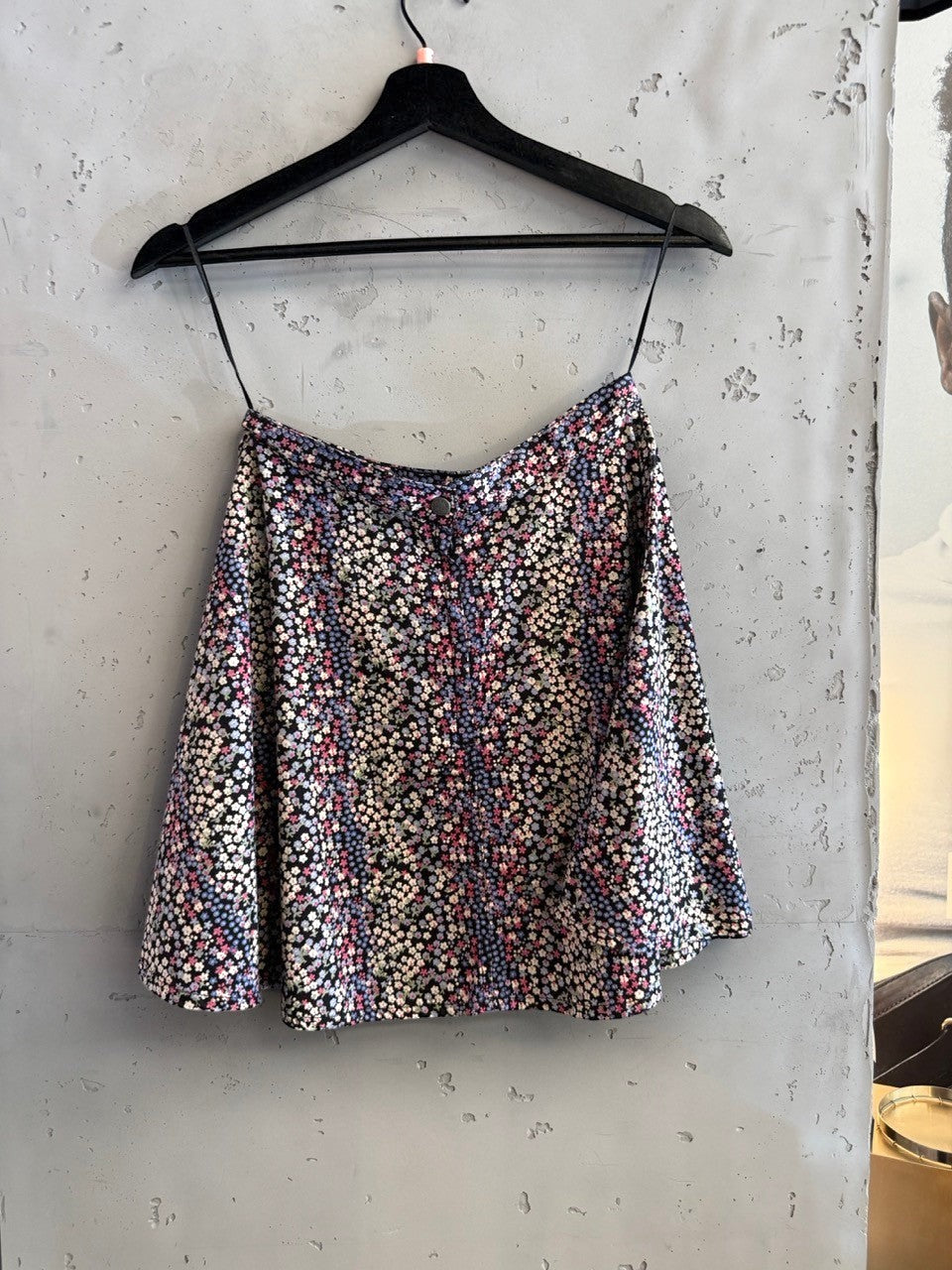 BERLIN VINTAGE CORNER black mini skirt with ditsy floral print in pink, blue, and white. A-line silhouette.
