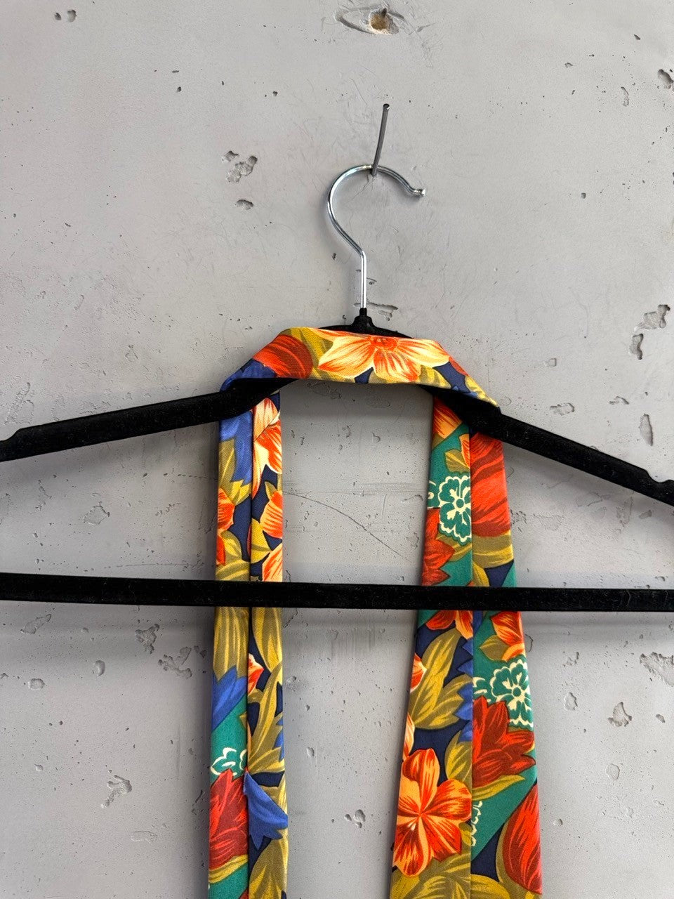 BERLIN VINTAGE CORNER navy tie with bold orange, red, and green floral pattern and diagonal green bands.
