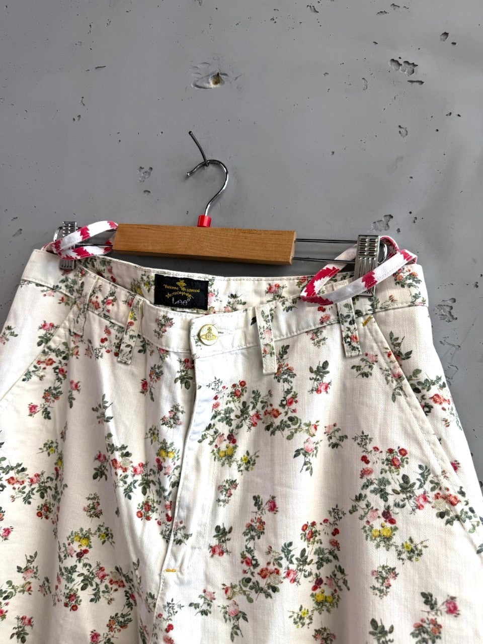 BERLIN VINTAGE CORNER white denim jeans with all-over pink, red, and yellow floral print and a matching belt.
