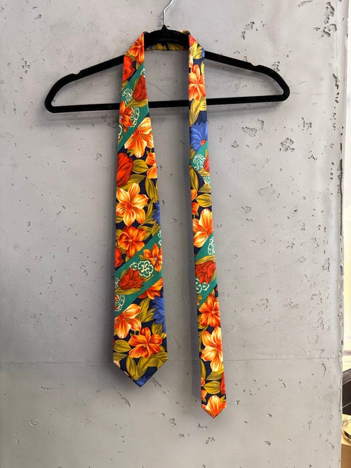 BERLIN VINTAGE CORNER navy tie with bold orange, red, and blue floral pattern and green diagonal stripes.