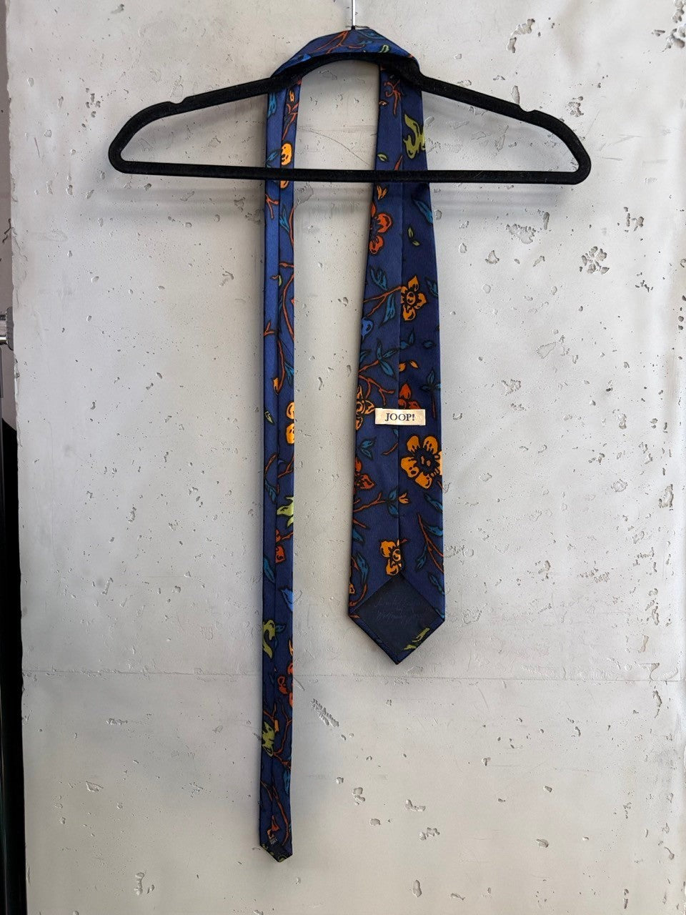 BERLIN VINTAGE CORNER navy blue tie with orange and yellow floral pattern, textured fabric.