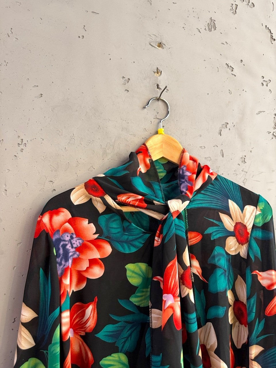 BERLIN VINTAGE CORNER long sleeve blouse with a vibrant floral print on black fabric and a chic high-neck tie detail.