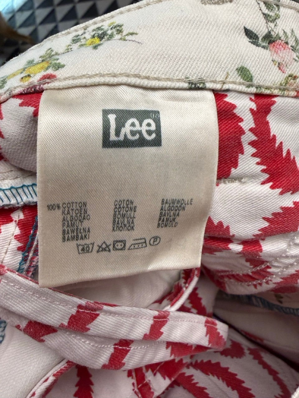 BERLIN VINTAGE CORNER white cotton twill trousers with pink, yellow, and green floral print and red zigzag pattern lining.