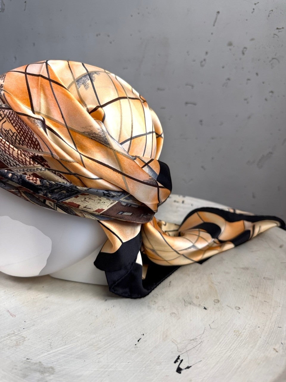 BERLIN VINTAGE CORNER silk scarf with peach and black geometric grid pattern draped on a mannequin head