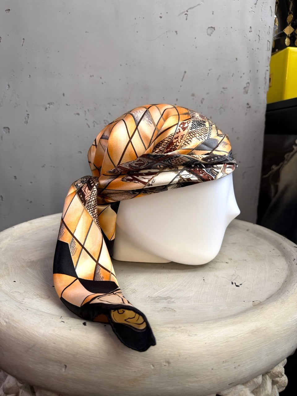 BERLIN VINTAGE CORNER silk scarf with geometric peach and black pattern draped on a mannequin head