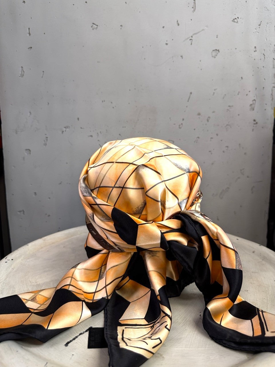 BERLIN VINTAGE CORNER silk scarf featuring a peach and black geometric grid pattern draped on a white surface.
