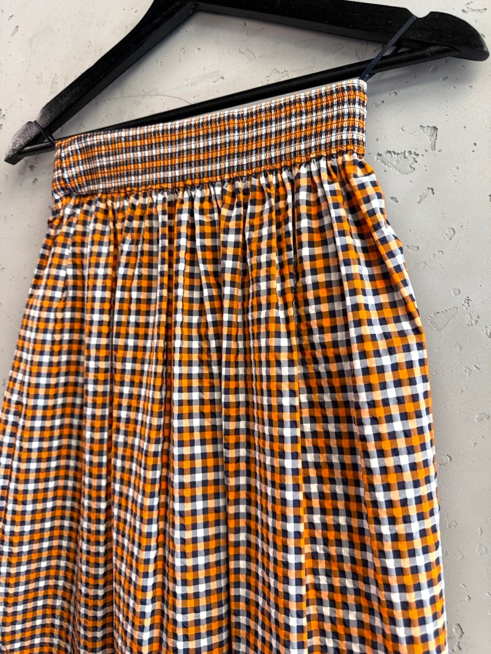 BERLIN VINTAGE CORNER orange, white, and black gingham check midi skirt with smocked waistband.
