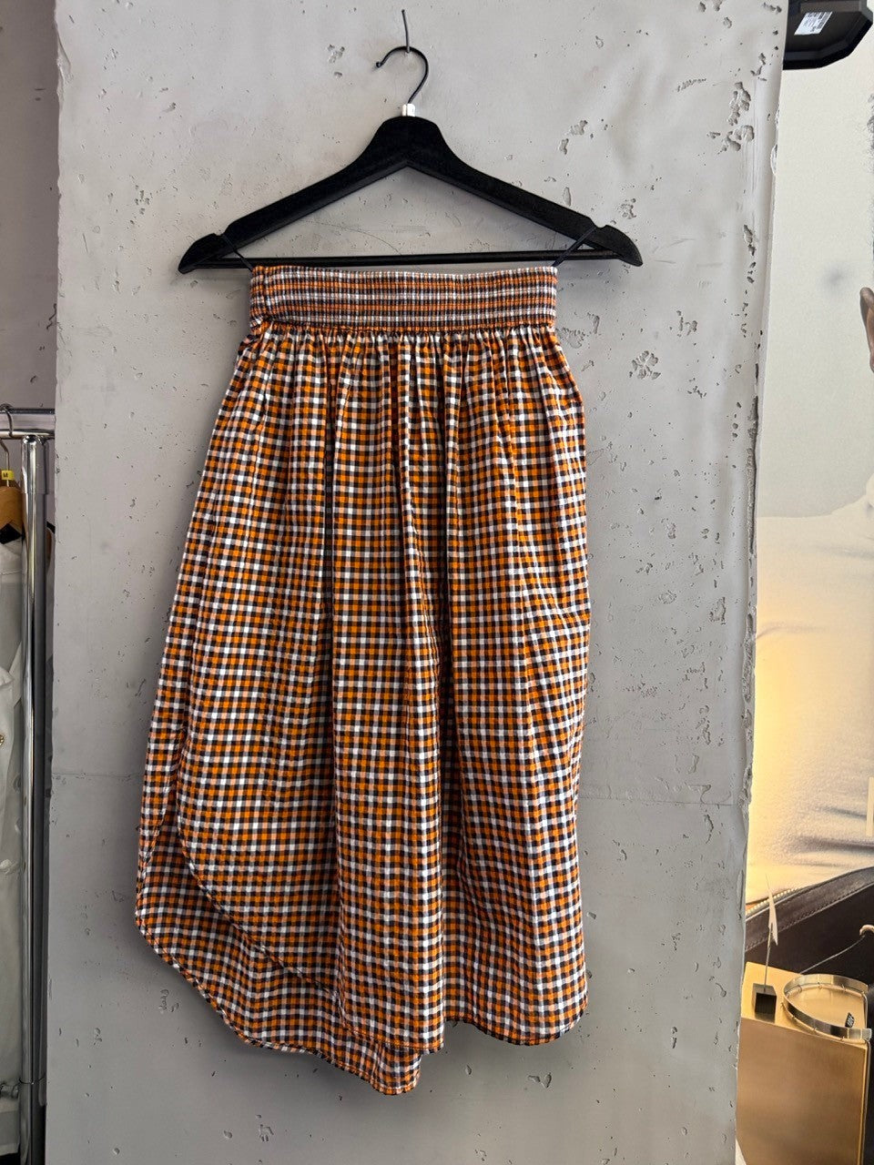 BERLIN VINTAGE CORNER orange, white, and black gingham check midi skirt with smocked waistband and A-line silhouette.