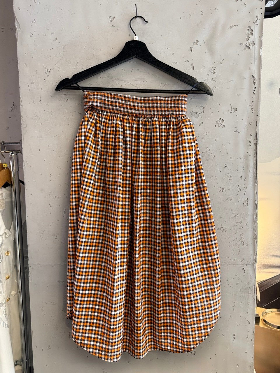 BERLIN VINTAGE CORNER orange, white, and black gingham check midi skirt with smocked waistband and A-line silhouette.