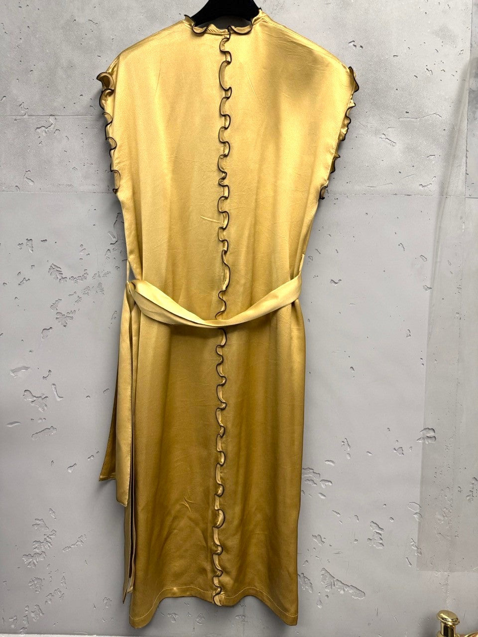 BERLIN VINTAGE CORNER gold satin midi dress with ruffled trim, V-neck, sleeveless, and matching belt.