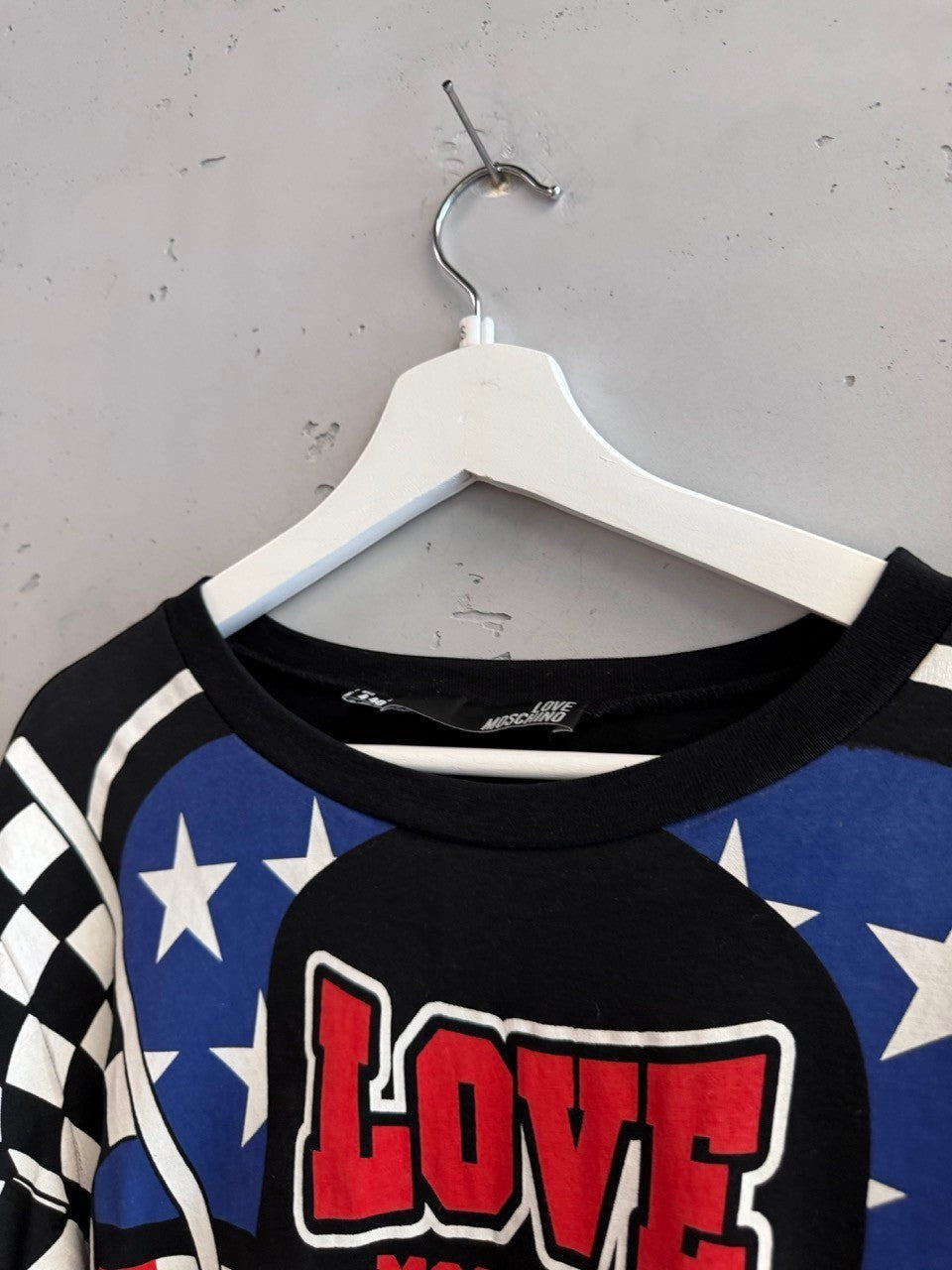 BERLIN VINTAGE CORNER black cotton t-shirt with graphic print featuring American flag elements, checkered pattern, and LOVE MOSCHINO logo.