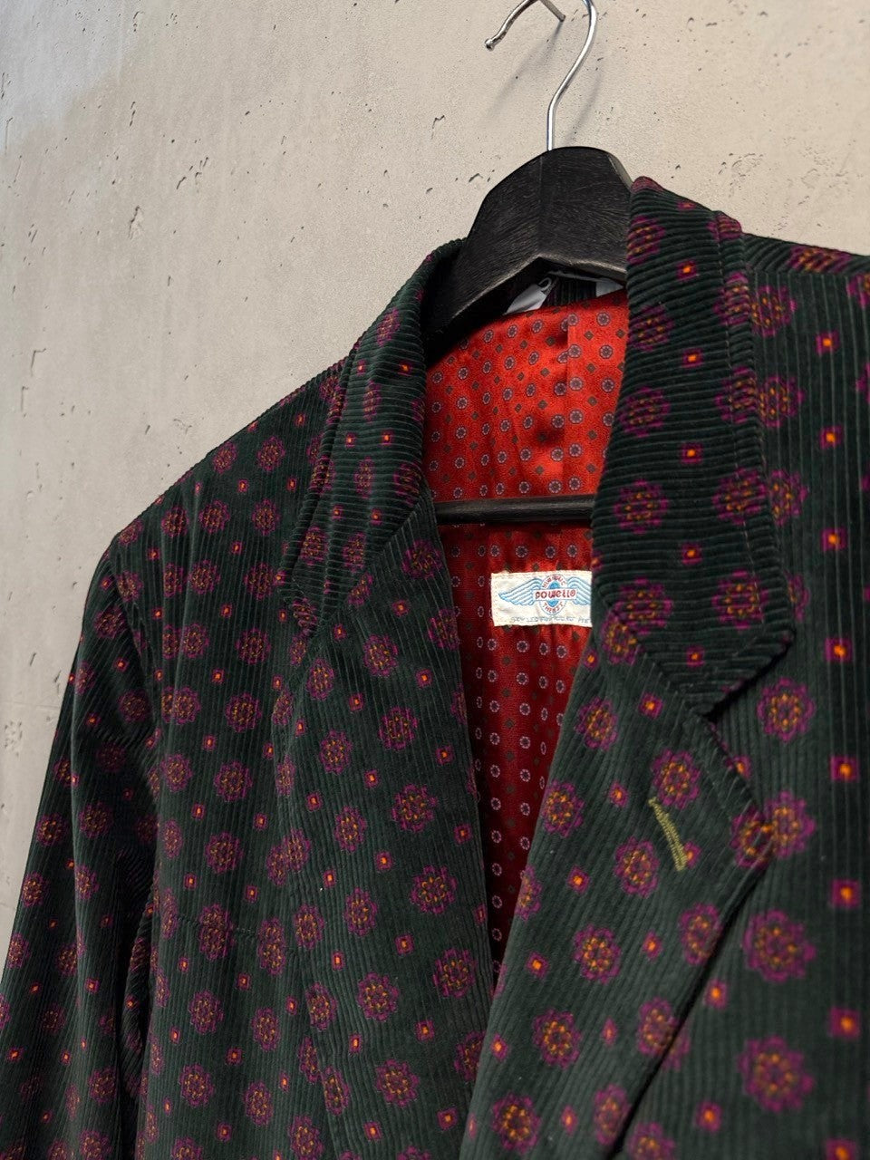 BERLIN VINTAGE CORNER green corduroy blazer with geometric print and red patterned lining. Features classic lapels and button closure.