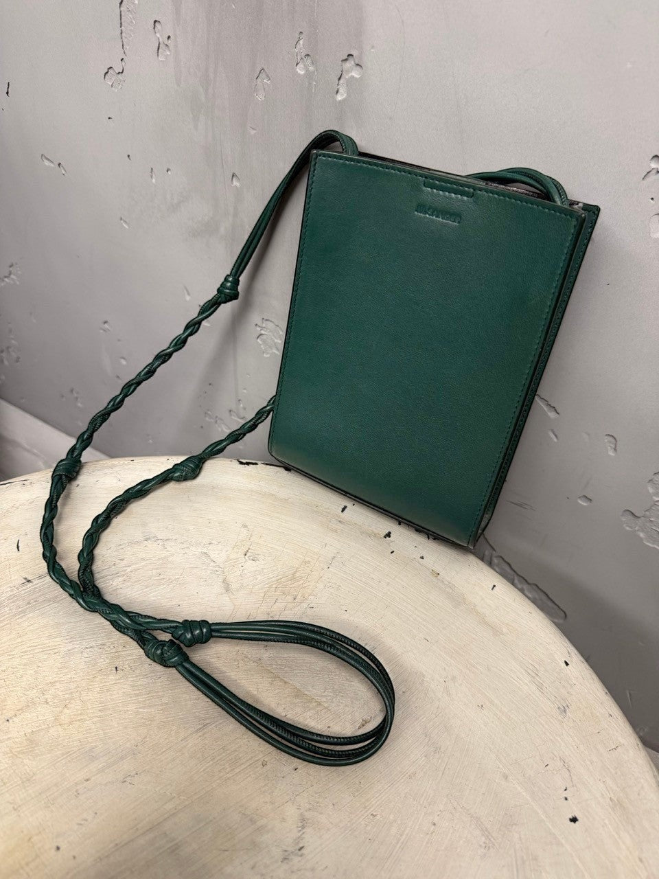 BERLIN VINTAGE CORNER forest green leather crossbody bag with braided adjustable strap and embossed logo.