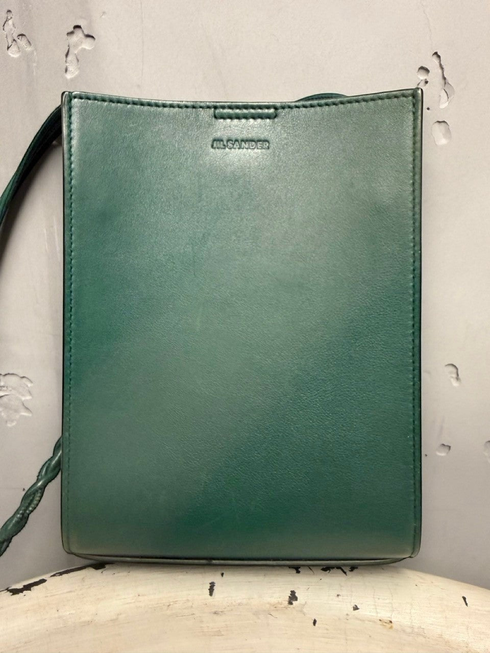 BERLIN VINTAGE CORNER forest green leather crossbody bag with braided strap and embossed logo.