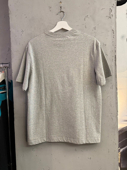 BERLIN VINTAGE CORNER heather grey cotton crewneck t-shirt, back view hanging on a white hanger against a concrete wall.