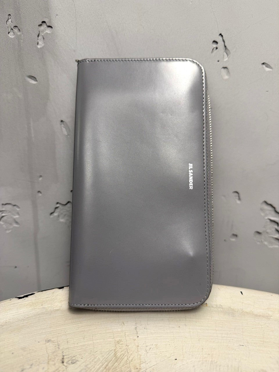 BERLIN VINTAGE CORNER grey leather zip-around wallet with embossed logo and braided wrist strap.