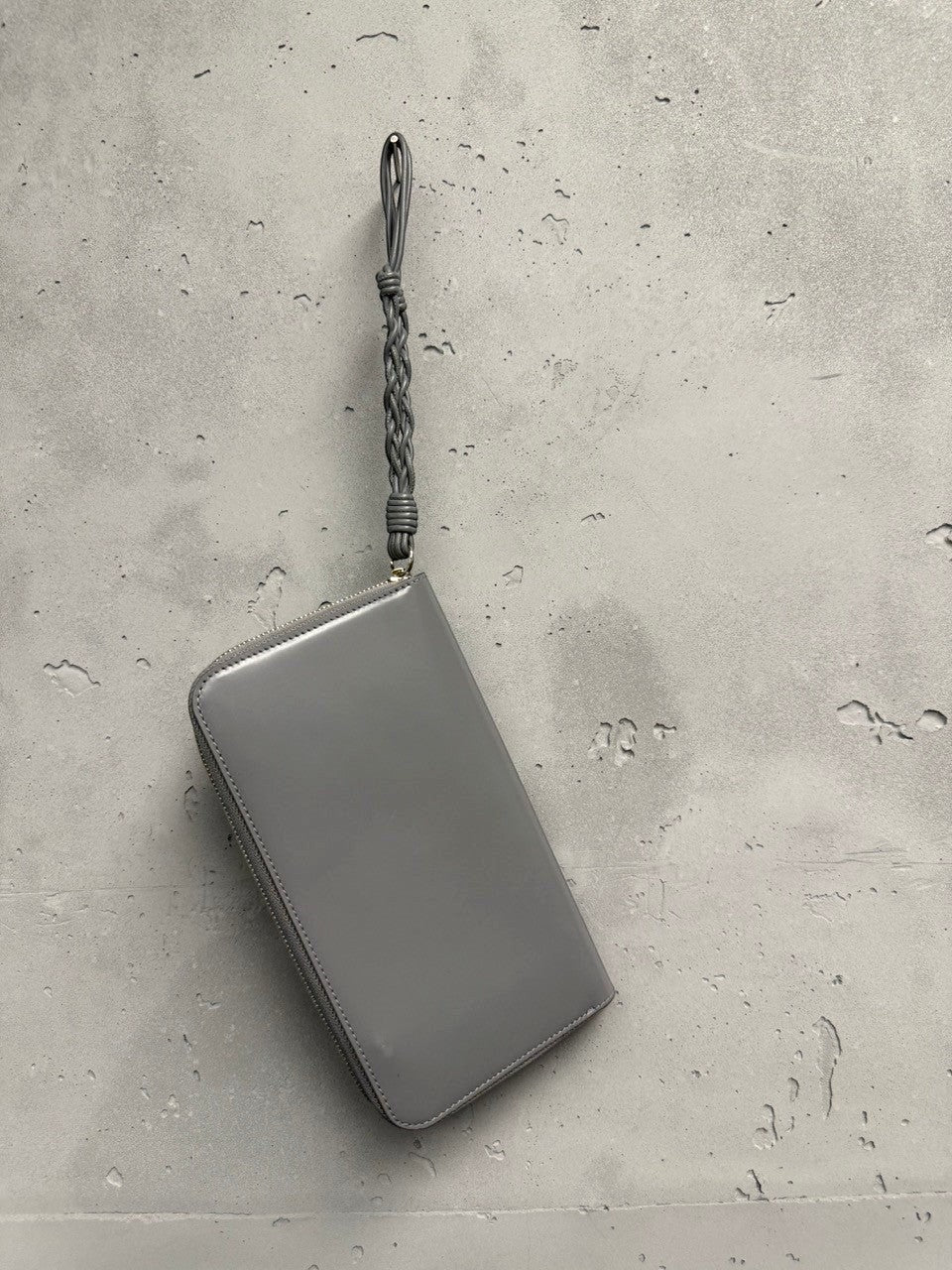 BERLIN VINTAGE CORNER grey polished leather zip-around wallet with braided wrist strap.