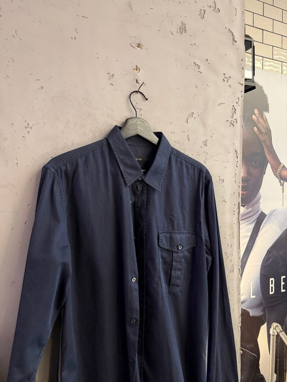BERLIN VINTAGE CORNER navy blue Gucci long sleeve button down shirt with chest pocket hanging on a wall