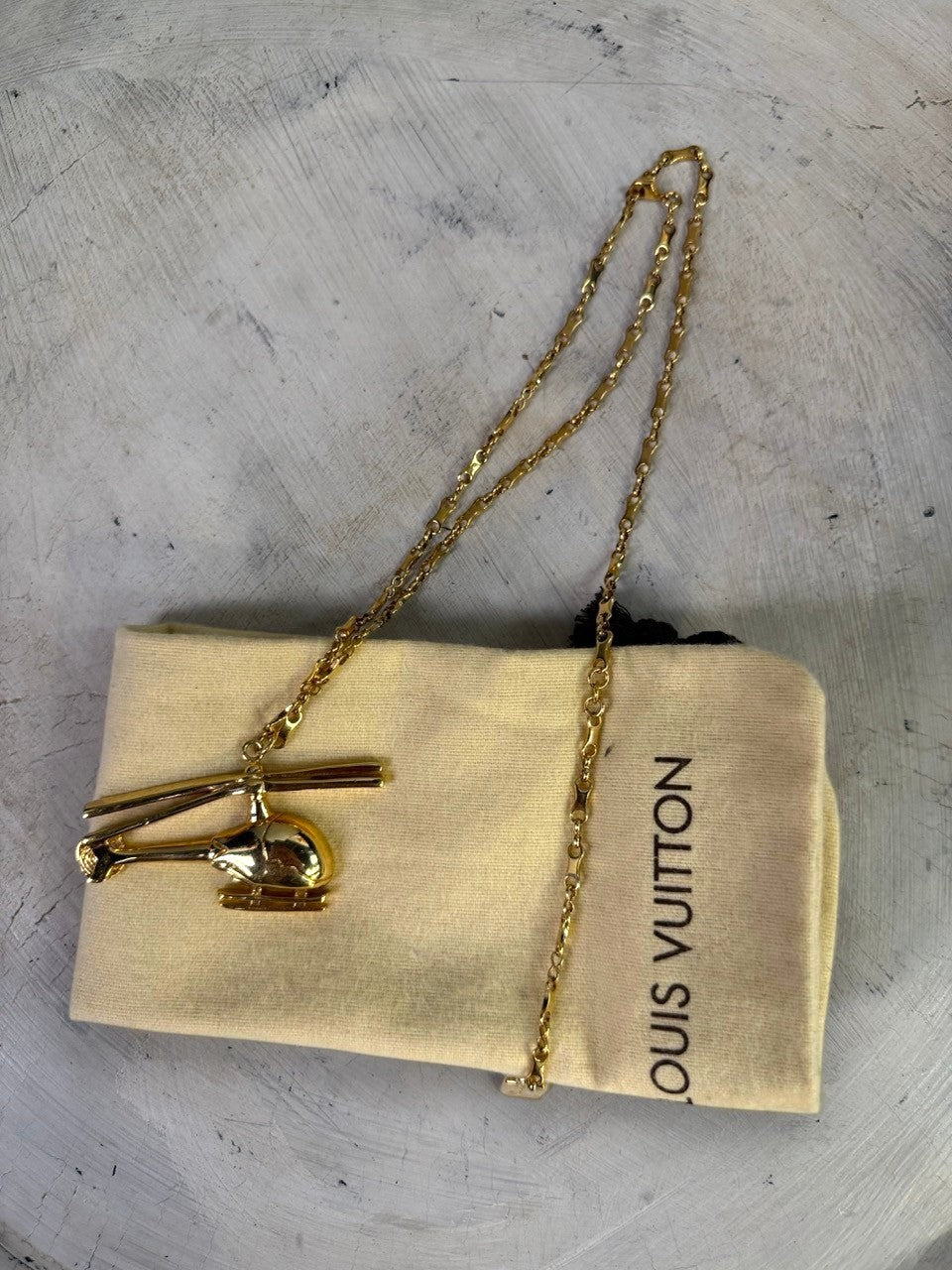 BERLIN VINTAGE CORNER gold-tone helicopter pendant necklace with delicate chain and Louis Vuitton pouch.