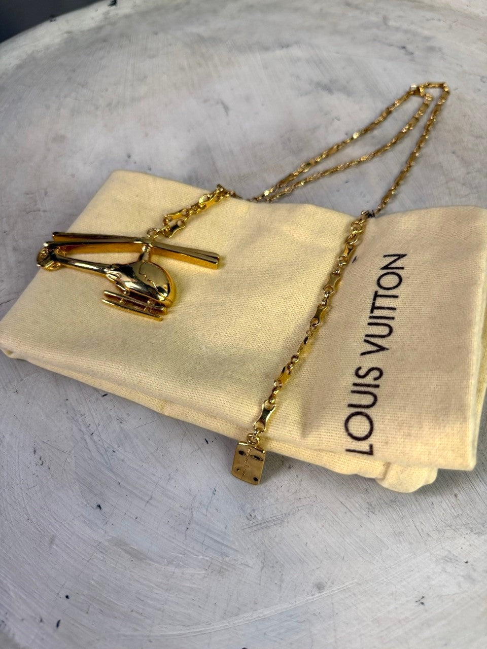 BERLIN VINTAGE CORNER gold-tone helicopter pendant necklace with Louis Vuitton pouch and small embossed charm.