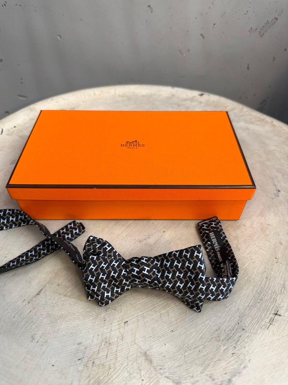 BERLIN VINTAGE CORNER black, white, and brown silk bow tie with all-over H pattern. Self-tie design.
