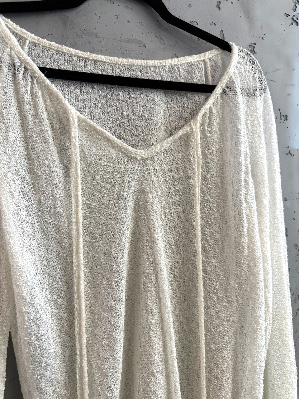 BERLIN VINTAGE CORNER ivory sheer knit V-neck pullover sweater with drawstring detail and long sleeves.