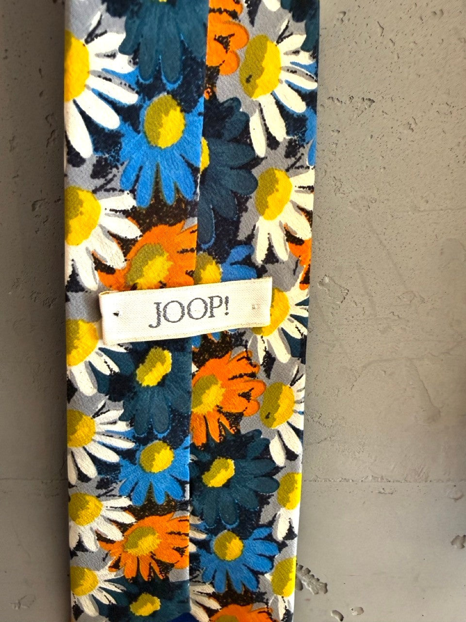 BERLIN VINTAGE CORNER JOOP! navy blue tie with a scattered daisy print in white, orange, and blue.