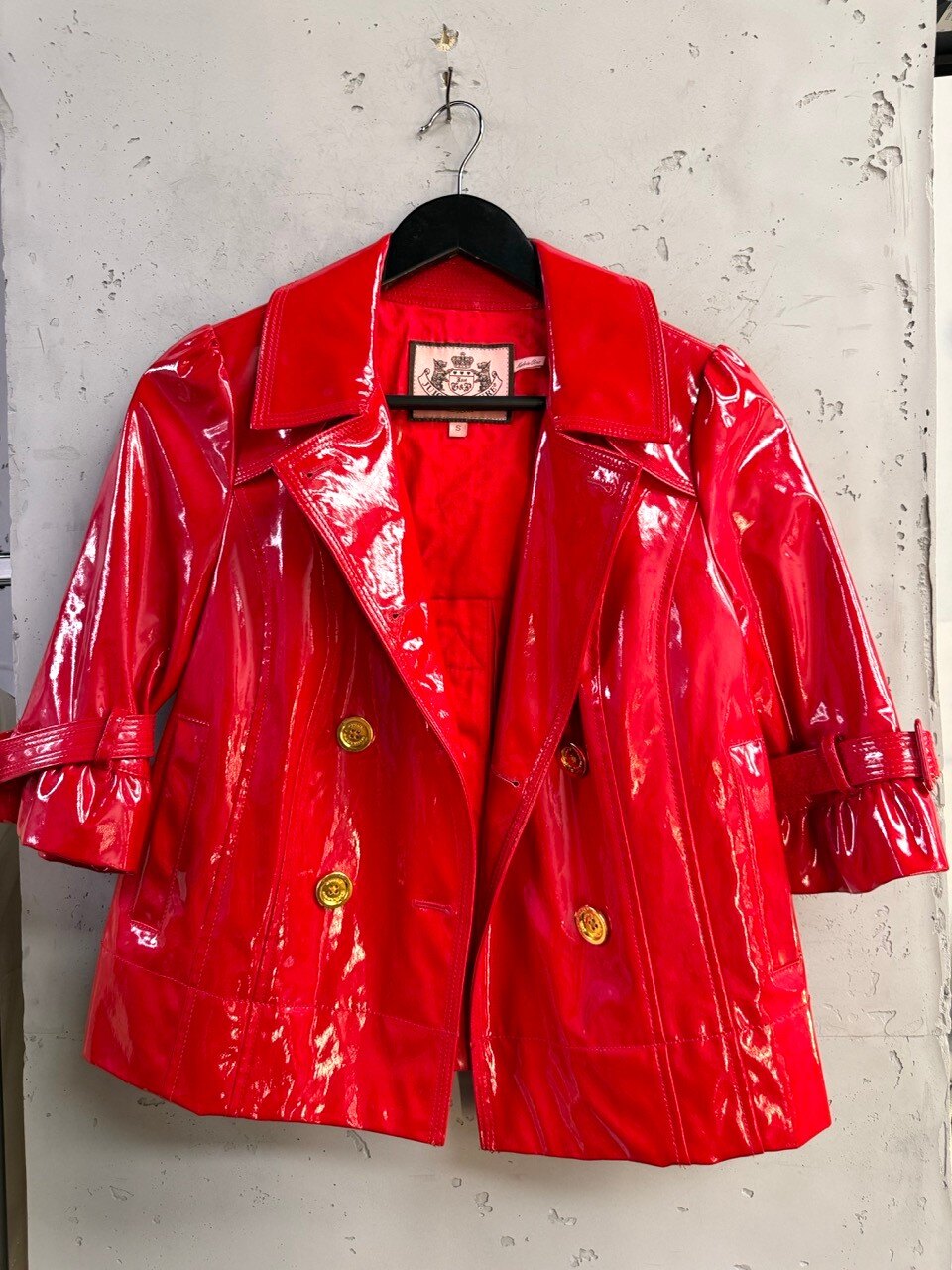 Juicy Couture red patent trench coat, front view on a hanger