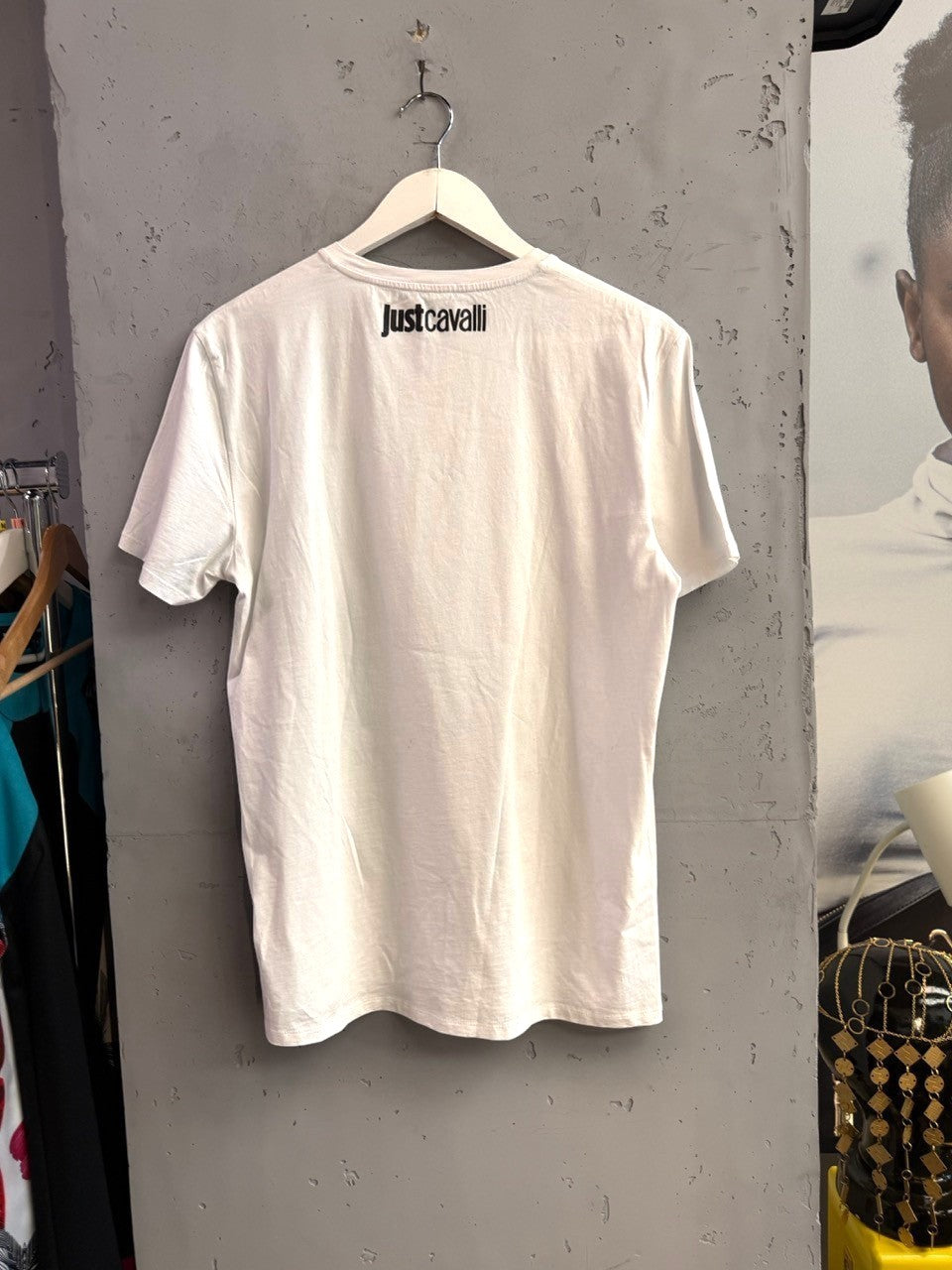 BERLIN VINTAGE CORNER white Just Cavalli crew neck t-shirt with black logo on the back, hanging on a white hanger.