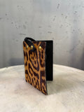 BERLIN VINTAGE CORNER leopard print calf hair card holder with black leather strap and snap closure.