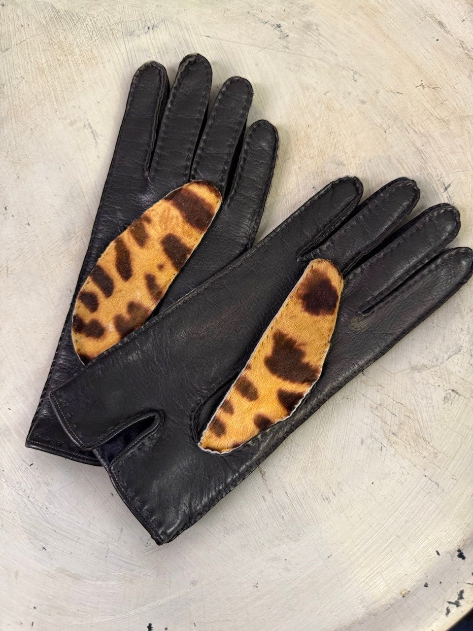 BERLIN VINTAGE CORNER black leather gloves with leopard print accent panels and black trim.