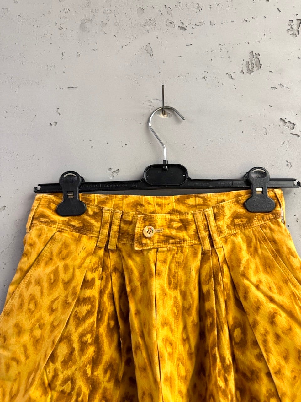 BERLIN VINTAGE CORNER mustard yellow leopard print pleated high-waisted shorts with button closure.