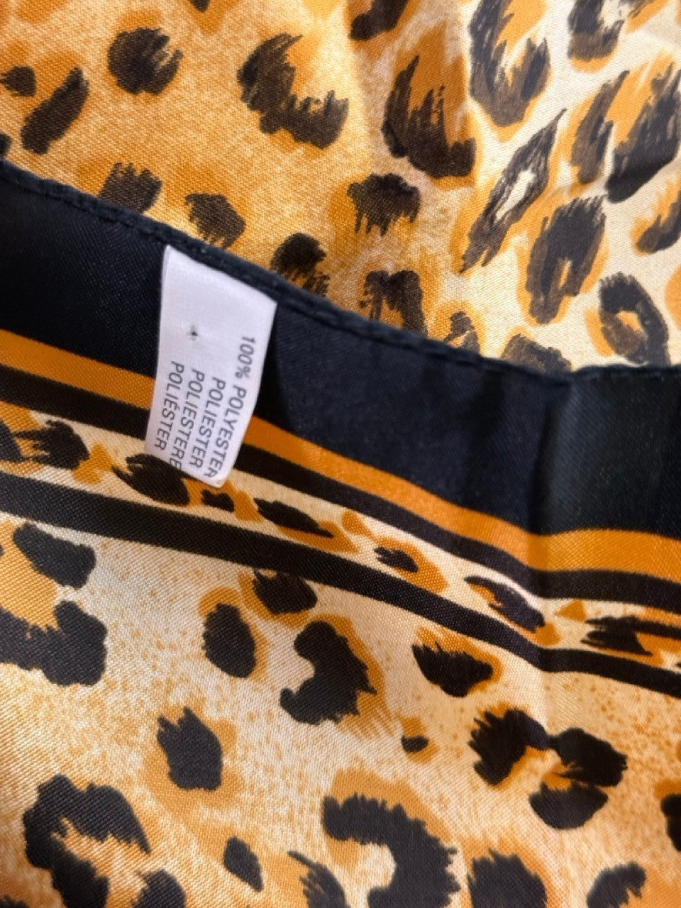 BERLIN VINTAGE CORNER leopard print square scarf in gold, tan, and black polyester with a decorative border.