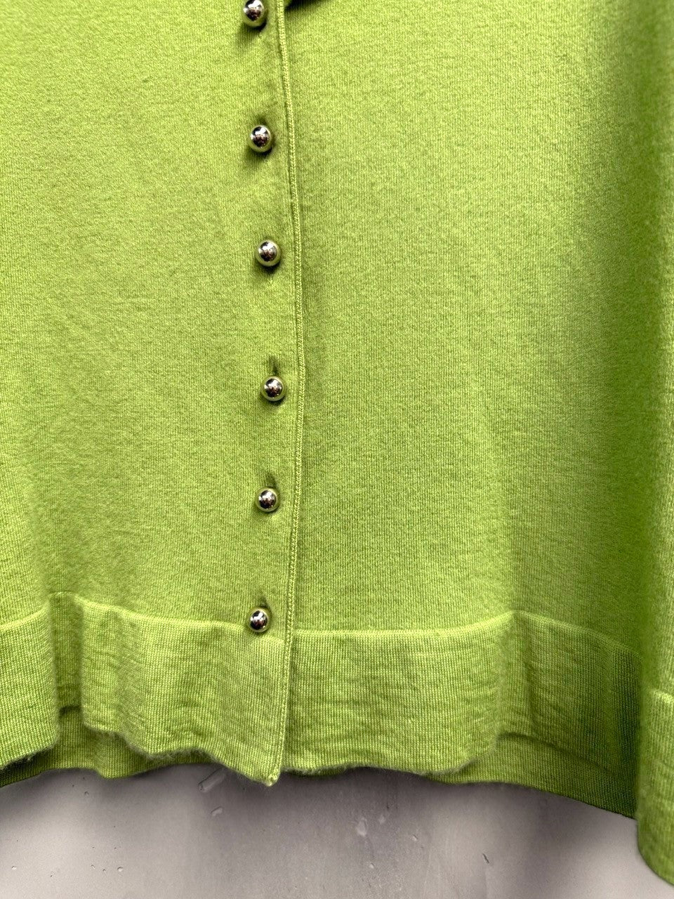 BERLIN VINTAGE CORNER lime green knit cardigan with silver buttons and ruffled trim. Three-quarter sleeves.