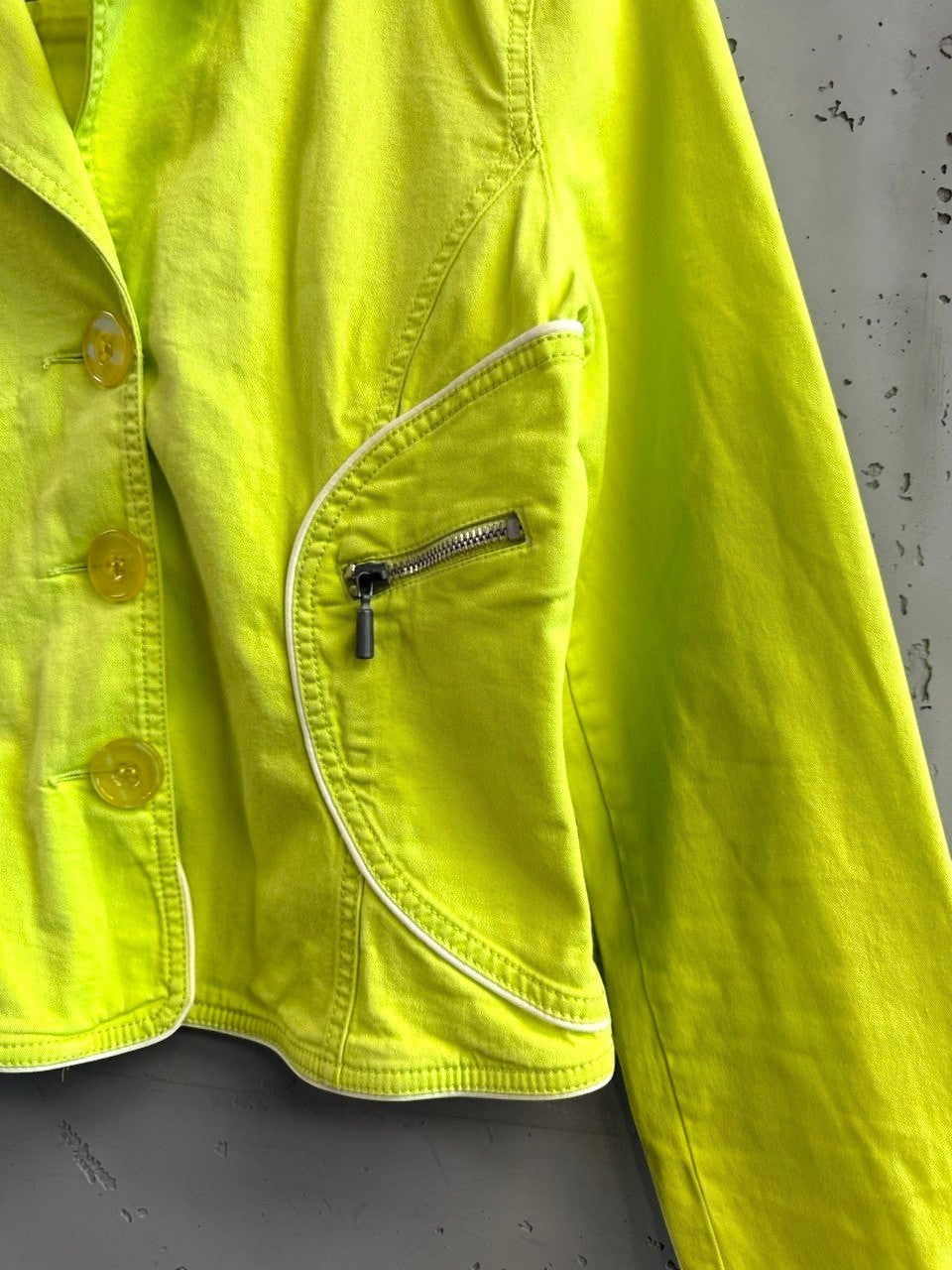 BERLIN VINTAGE CORNER lime green denim jacket with white piping, button front, and zippered side pockets.