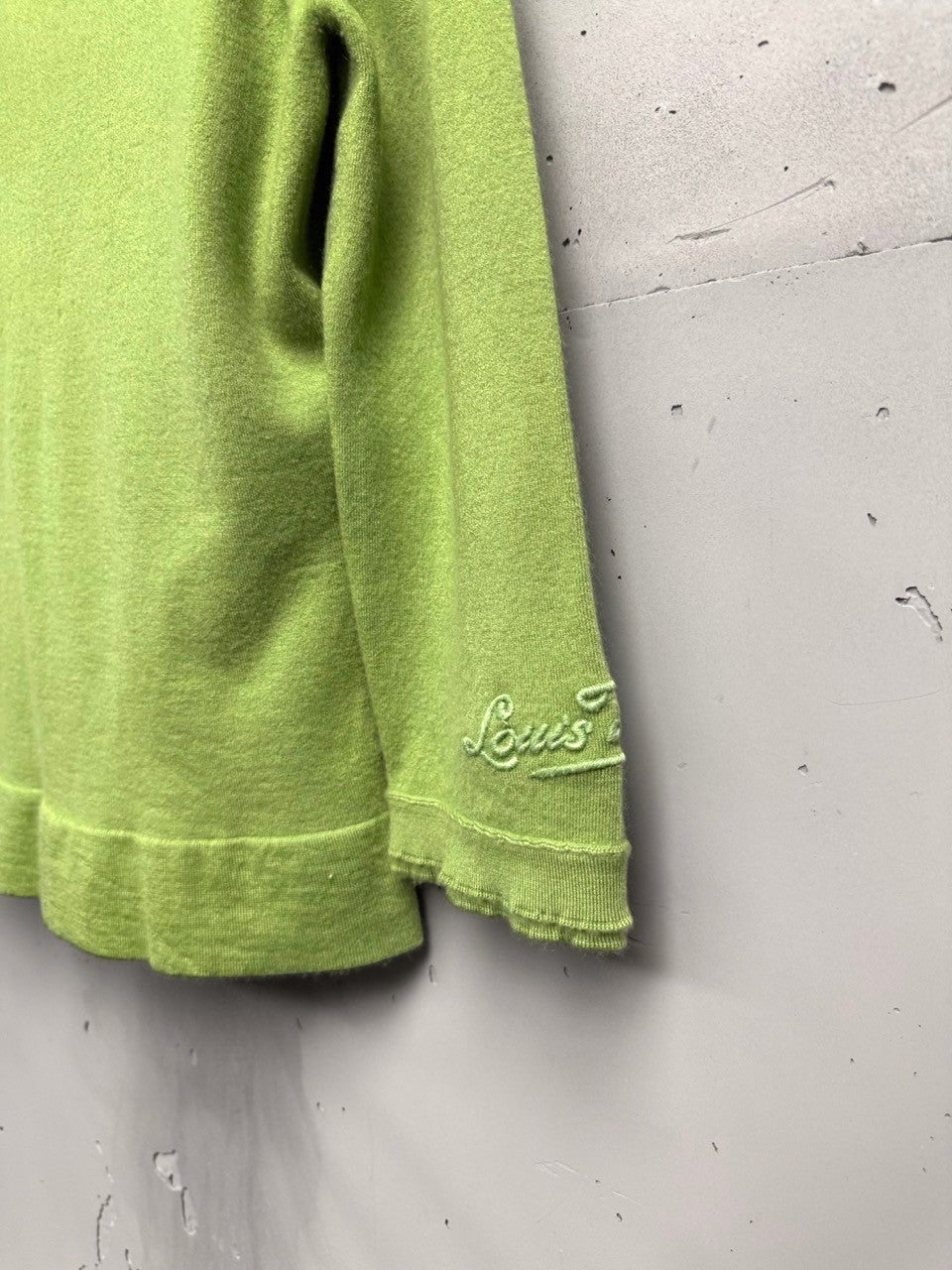 BERLIN VINTAGE CORNER lime green knit cardigan with embroidered logo on sleeve and ruffled neckline.