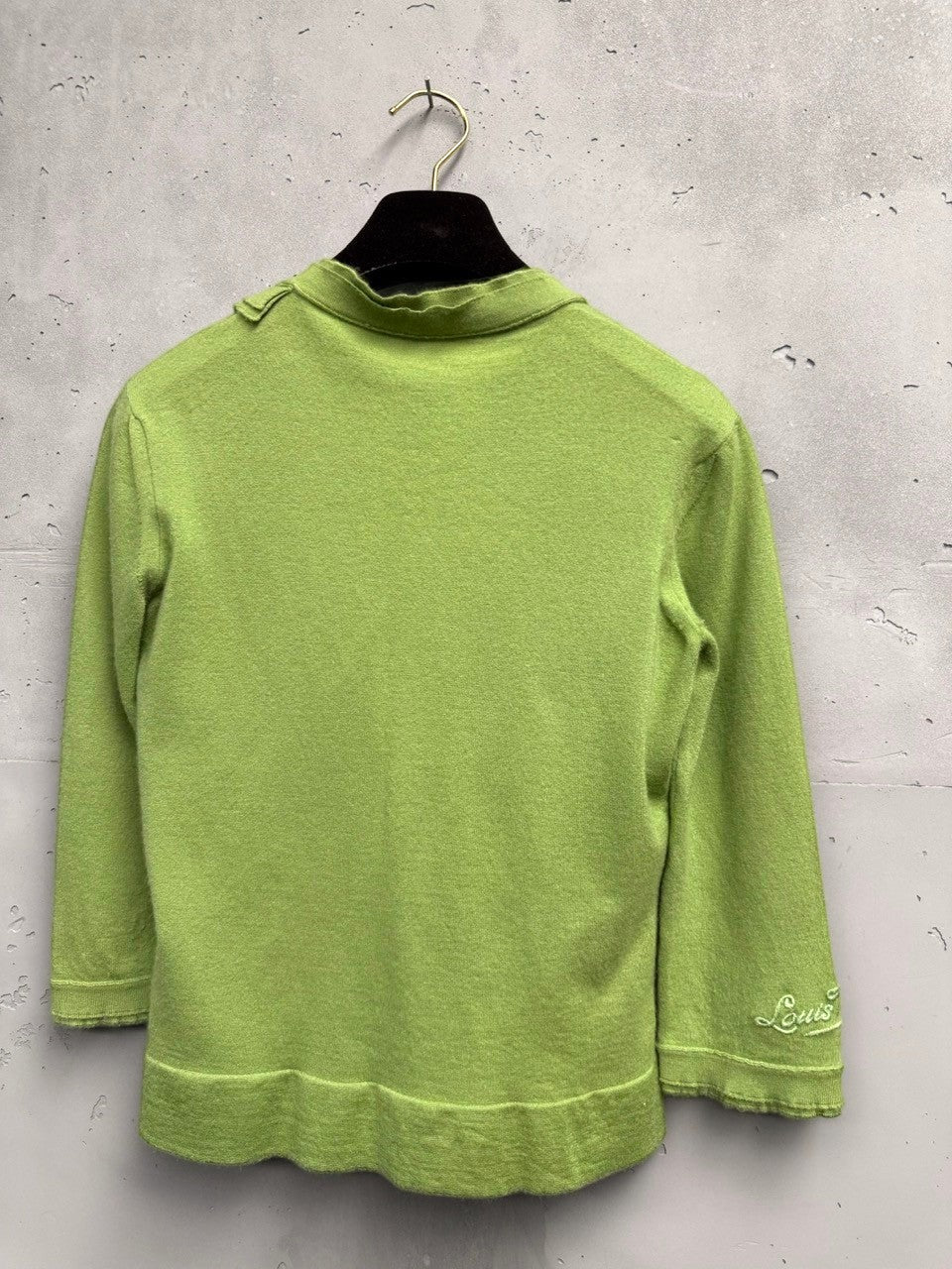 BERLIN VINTAGE CORNER lime green knit cardigan with ruffled neckline, silver buttons, and embroidered logo on sleeve.