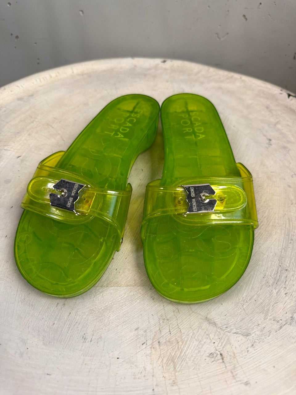 BERLIN VINTAGE CORNER lime green PVC jelly slides with silver buckle and embossed logo. Textured wood grain sole.
