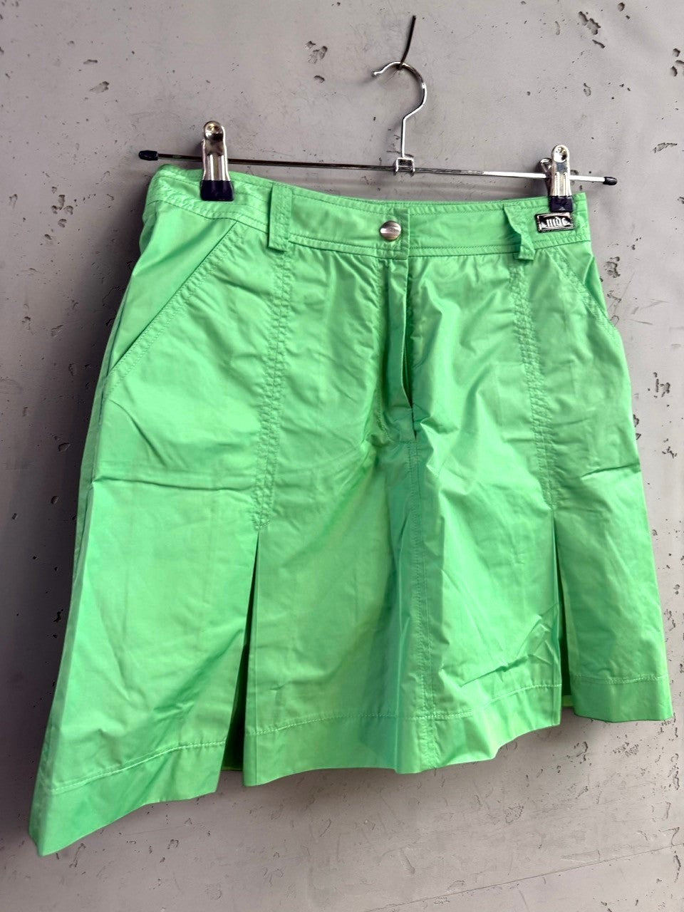 BERLIN VINTAGE CORNER lime green pleated mini skirt with side pockets, belt loops, and button closure.