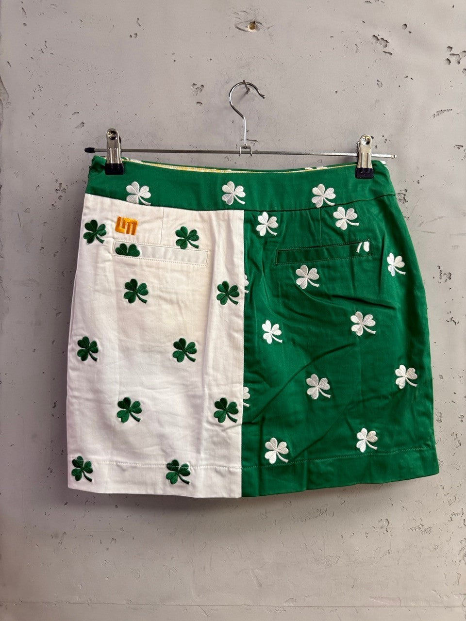 BERLIN VINTAGE CORNER Loudmouth green and white color-blocked golf mini skirt with embroidered shamrock pattern.